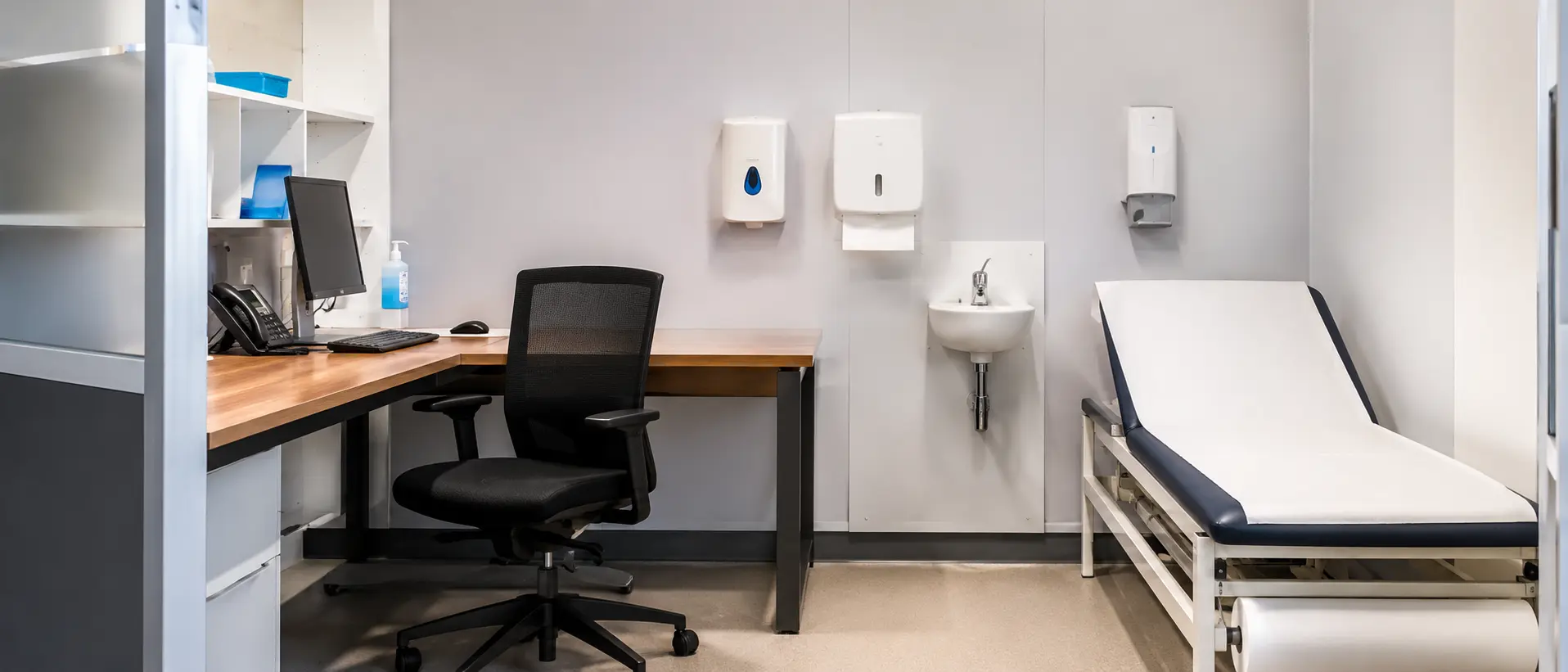 A clinician consulting with a patient at a desk in a consultation room